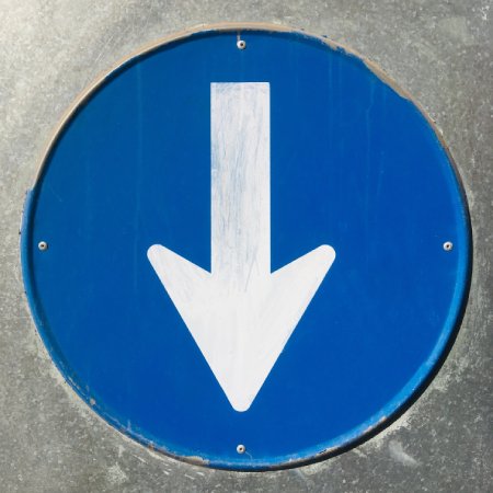 round blue sign with a down pointing white arrow