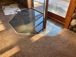 Water pools on the floor after a pipe burst in a Lake George home.
