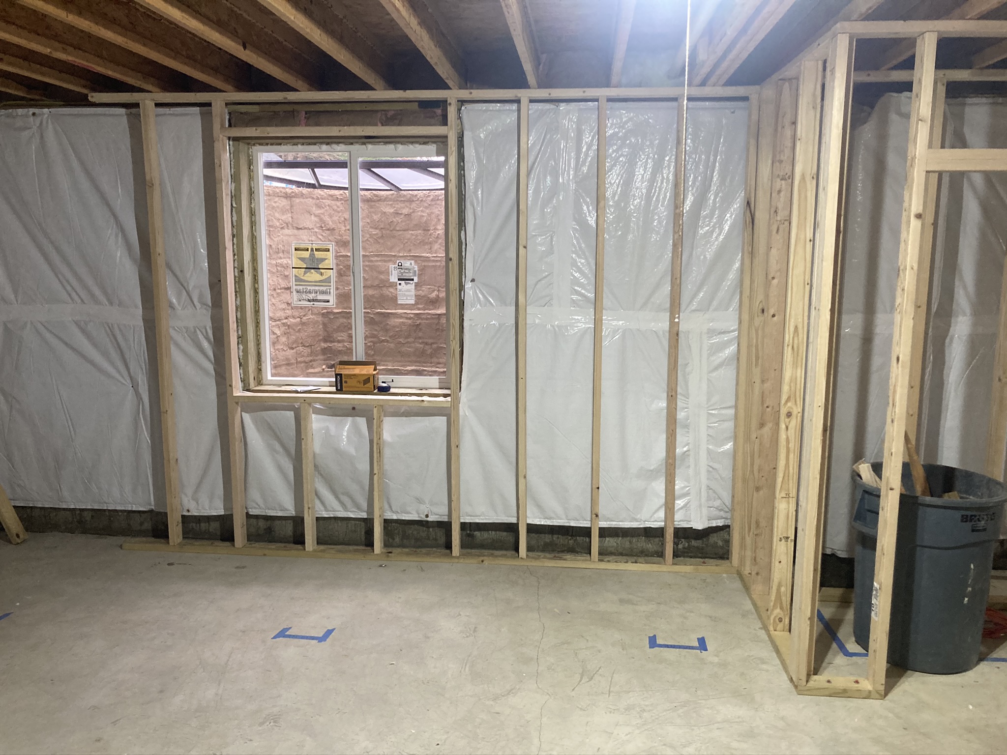 Newly framed wall beside a window in a basement during reconstruction