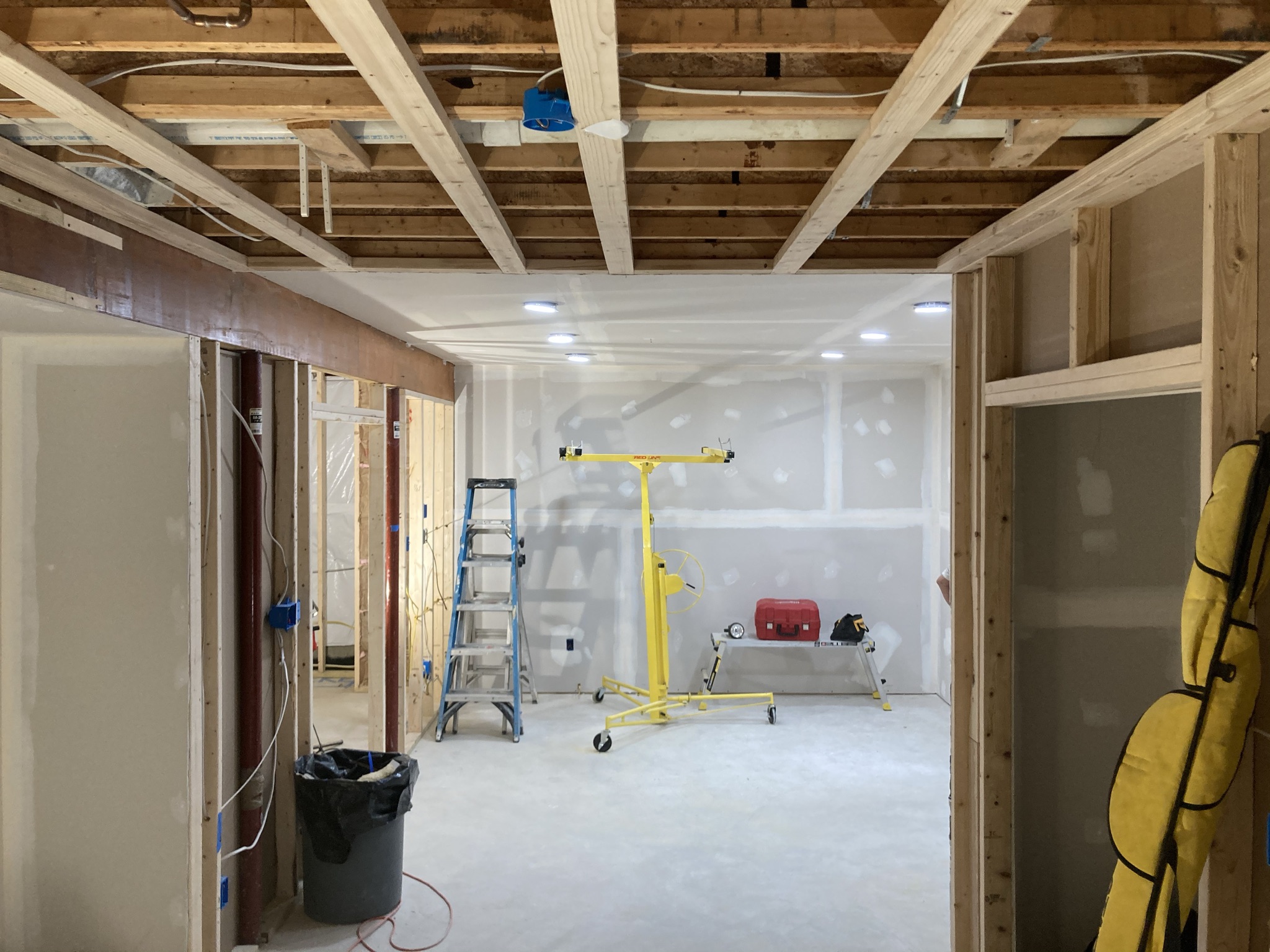 Basement rebuild with drywall partially hung and exposed ceiling joists