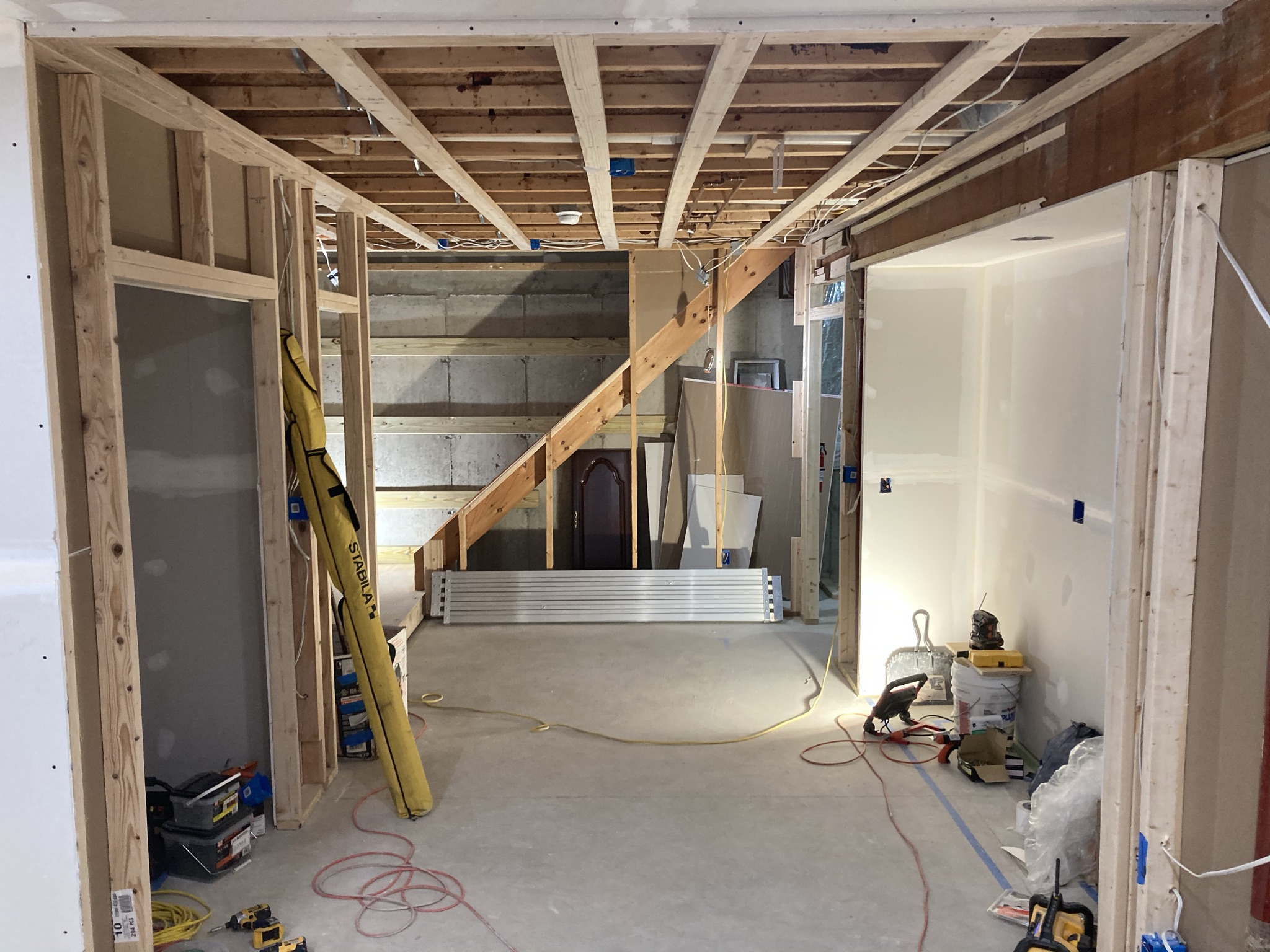 Basement reconstruction with framing, drywall, and a staircase