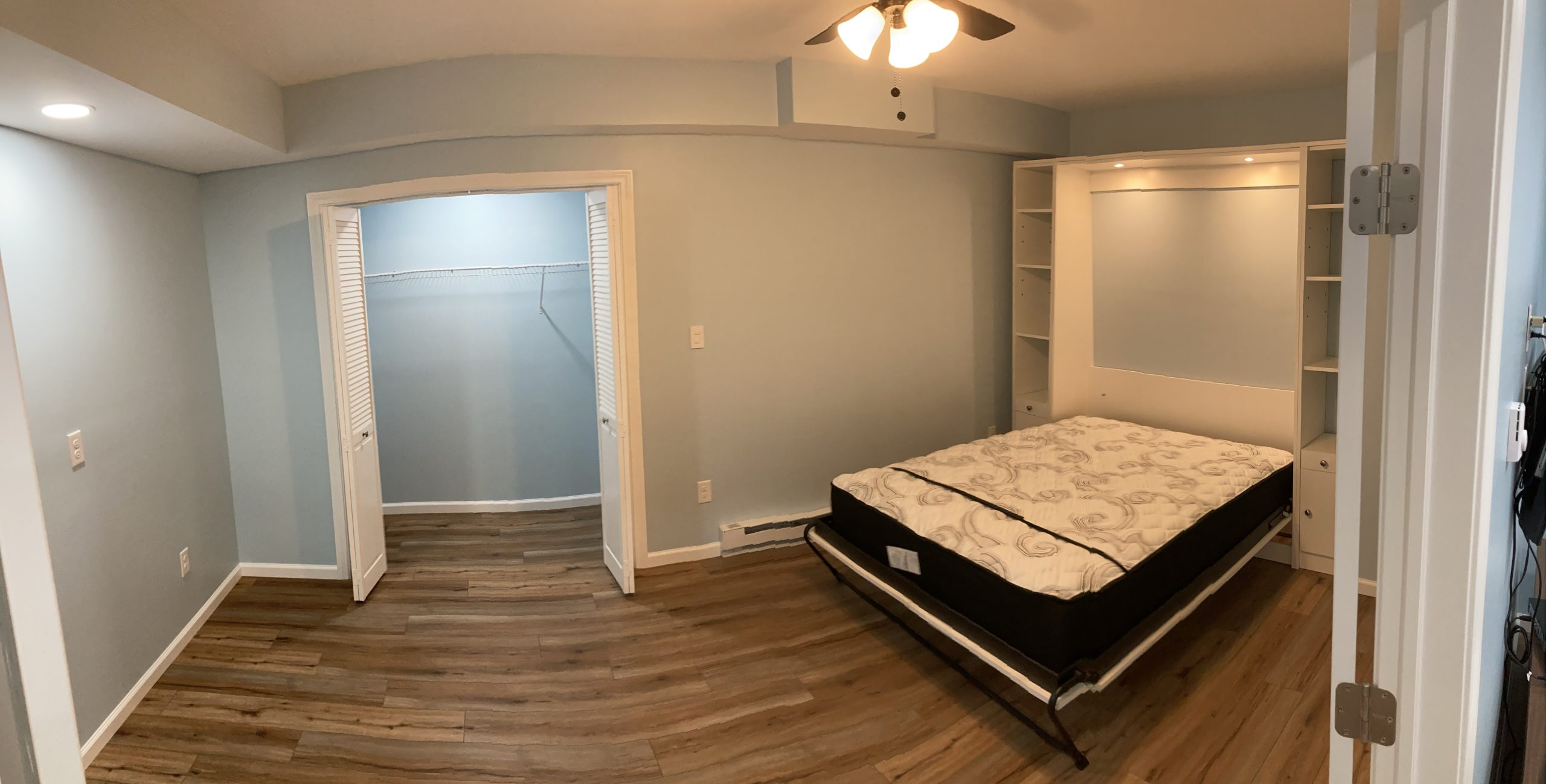 Finished basement bedroom with a bed, new flooring, and painted walls